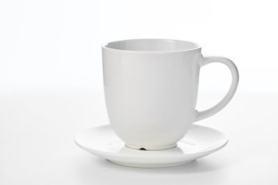 Close-up of coffee cup on table against white background