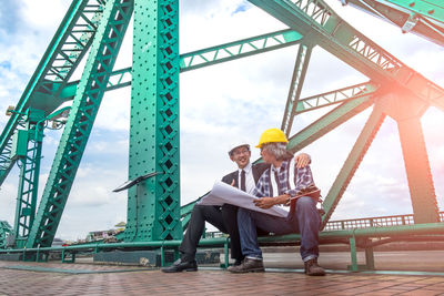 People on bridge against sky