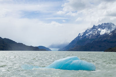 Scenic view of sea and mountains against sky