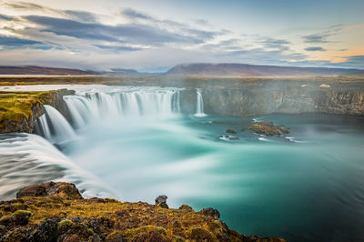 Scenic view of waterfall against sky