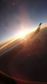 Close-up of airplane wing against sky during sunset