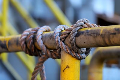 Close-up of rope tied on metal chain