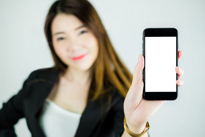 Portrait of woman photographing with mobile phone