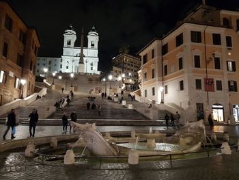 People at illuminated temple against sky at night