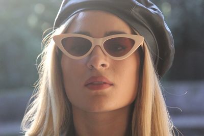 Close-up portrait of a young woman wearing sunglasses