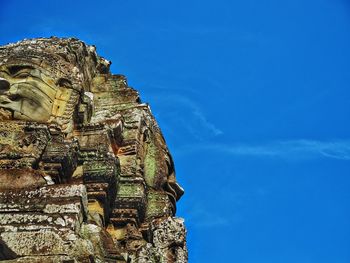 Low angle view of statue of temple against blue sky