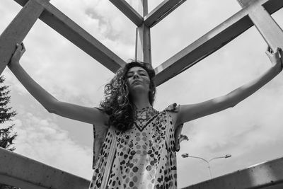 Low angle view of woman standing against sky