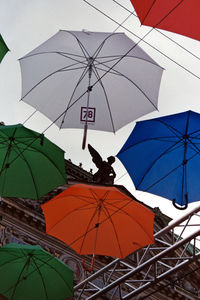 Low angle view of umbrellas hanging against sky