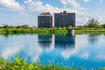 Scenic view of lake by buildings against sky