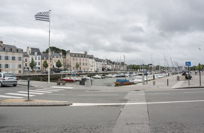 View of city street against cloudy sky