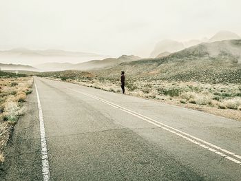 Man standing on road against sky