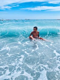 Full length of shirtless man in swimming pool against sky