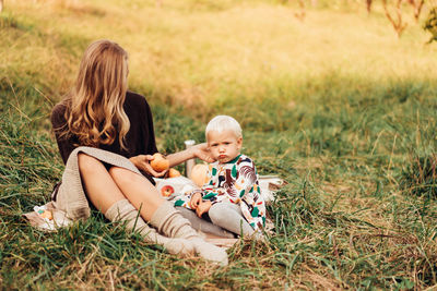 Mother and daughter sitting on grass