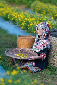 Woman wearing hat sitting on field