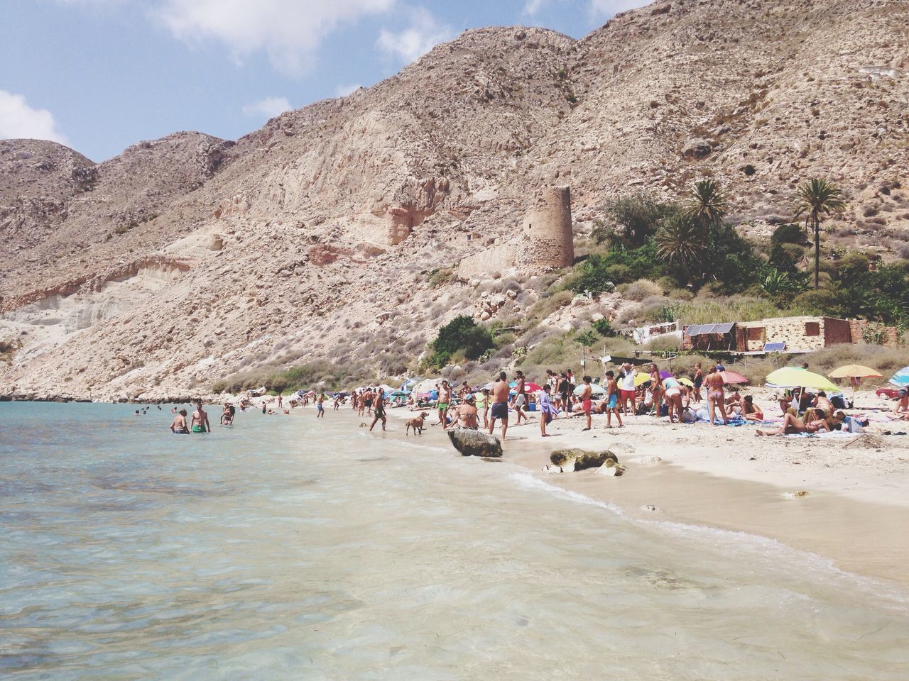 large group of people, beach, mountain, water, person, vacations, sky, tourist, lifestyles, men, leisure activity, sand, built structure, shore, sea, architecture, mixed age range, building exterior, tourism