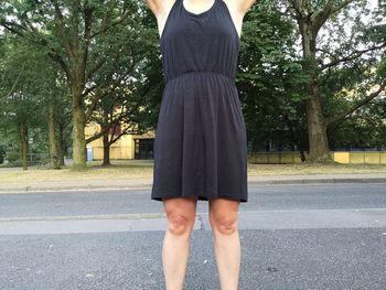 Low section of woman standing on road