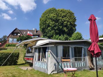 View of cottage and houses against sky