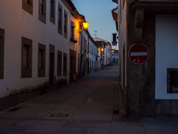 Empty road amidst buildings in city