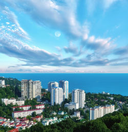 City buildings by sea against sky