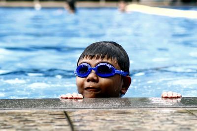 Boy wearing swimming goggles at pool