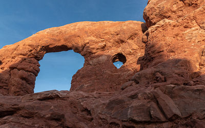 Scenic view of natural sandstone arches in arches national park with full moon framed in