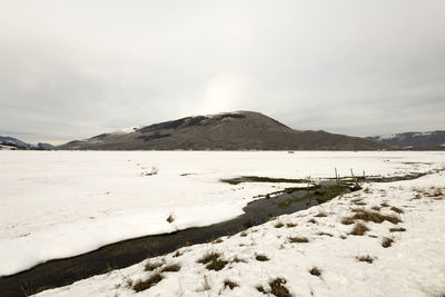 Scenic view of beach against sky during winter