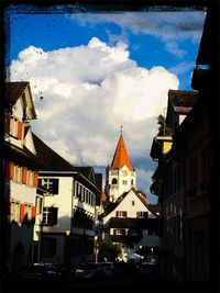 Buildings against cloudy sky