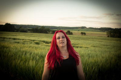 Portrait of redhead woman standing at farm