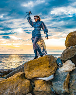 Full length of man standing on rock at beach
