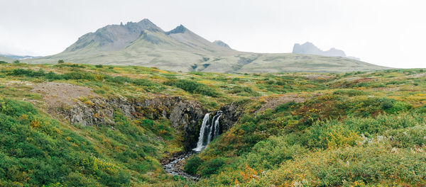 Scenic view of waterfall against sky