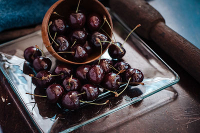 Close-up of cherry fruits in a wooden bowl on table