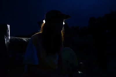 Silhouette man against illuminated sky at night