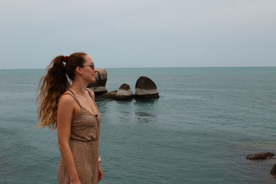 Rear view of woman looking at sea against sky