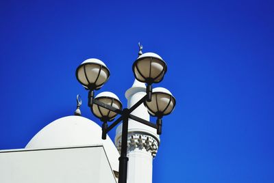 Low angle view of street light against blue sky