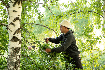 Side view of man holding food in forest