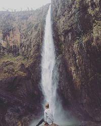 Rear view of woman looking at waterfall