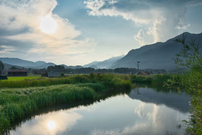 Scenic view of lake by mountains against sky