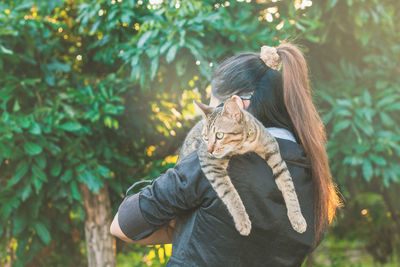 Portrait of young woman carrying cat