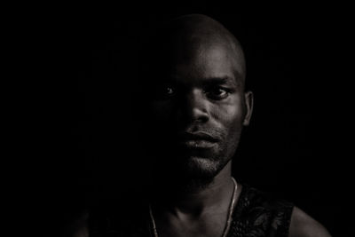 Portrait of man against black background