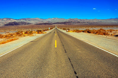 Road amidst field against sky