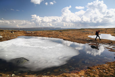 Hiker near frozen pond