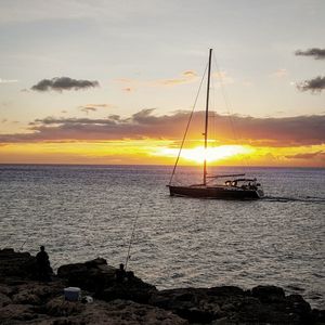 Sailboat in sea at sunset