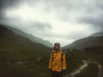 Portrait of man standing on mountain against sky