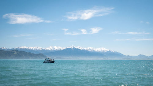 Boat on the ocean with mountain backdrop. shot at kaikoura peninsula, new zealand