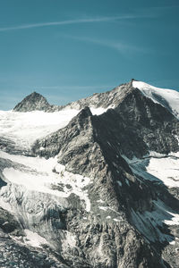 Scenic view of snowcapped mountains against blue sky
