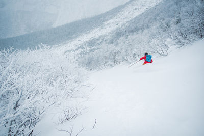Man skiing in deep snow in the alpine during a snowstorm in maine