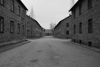 Empty road amidst buildings against sky