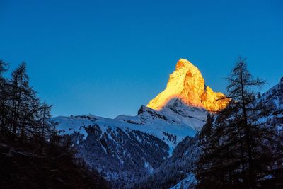 Scenic view of snowcapped mountain against clear blue sky