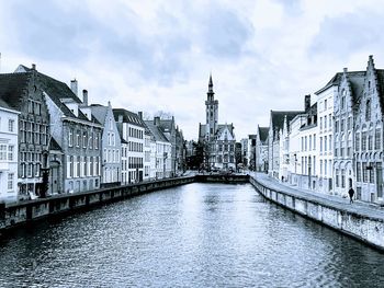 Bridge over river against buildings in city