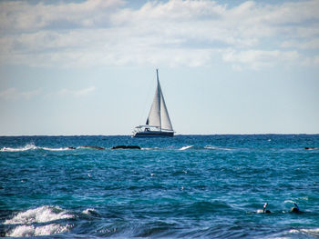 Sailboat sailing on sea against sky